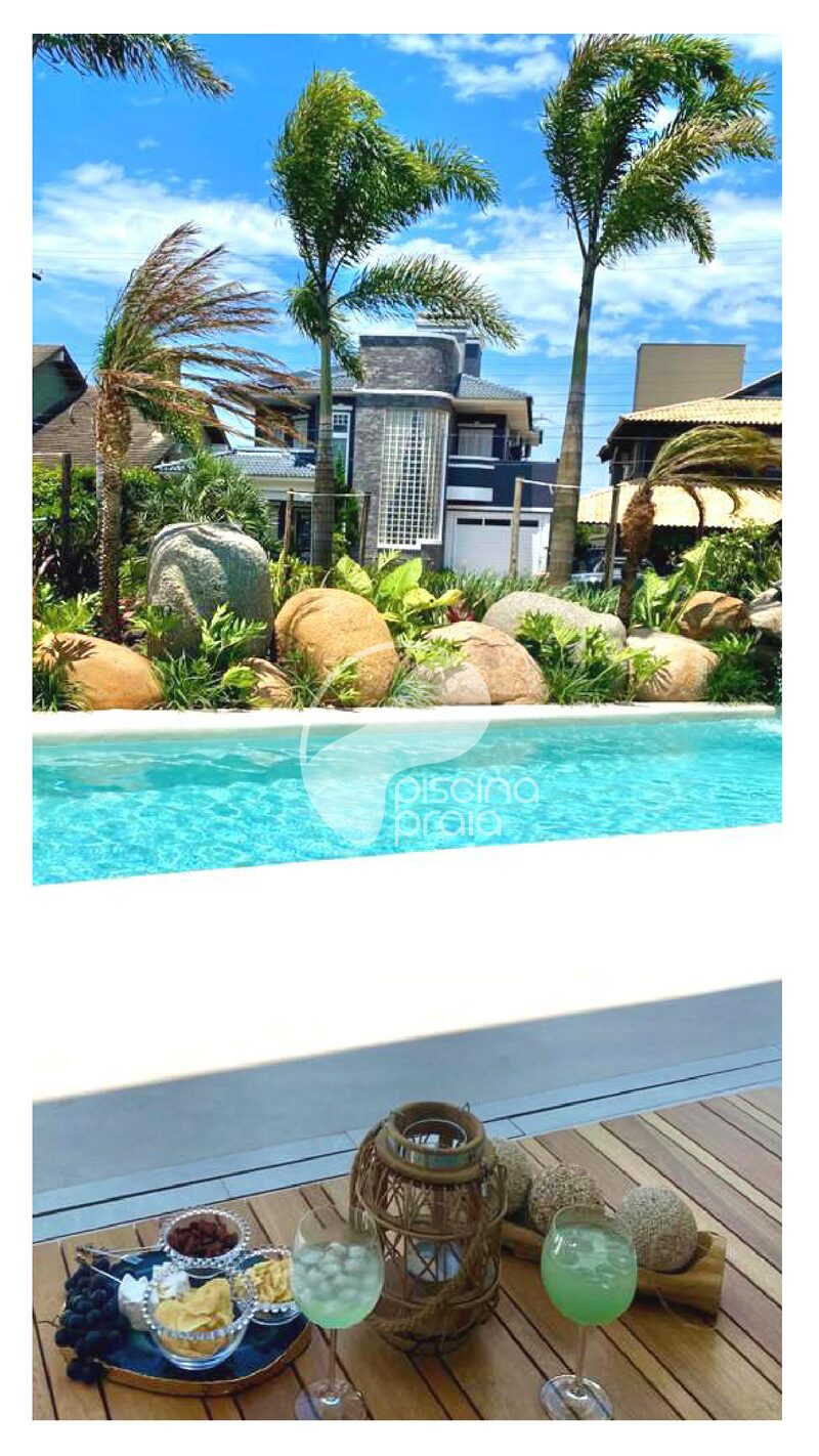 Piscina de condomínio com coqueiros e pedras, e drinks servidos no deck