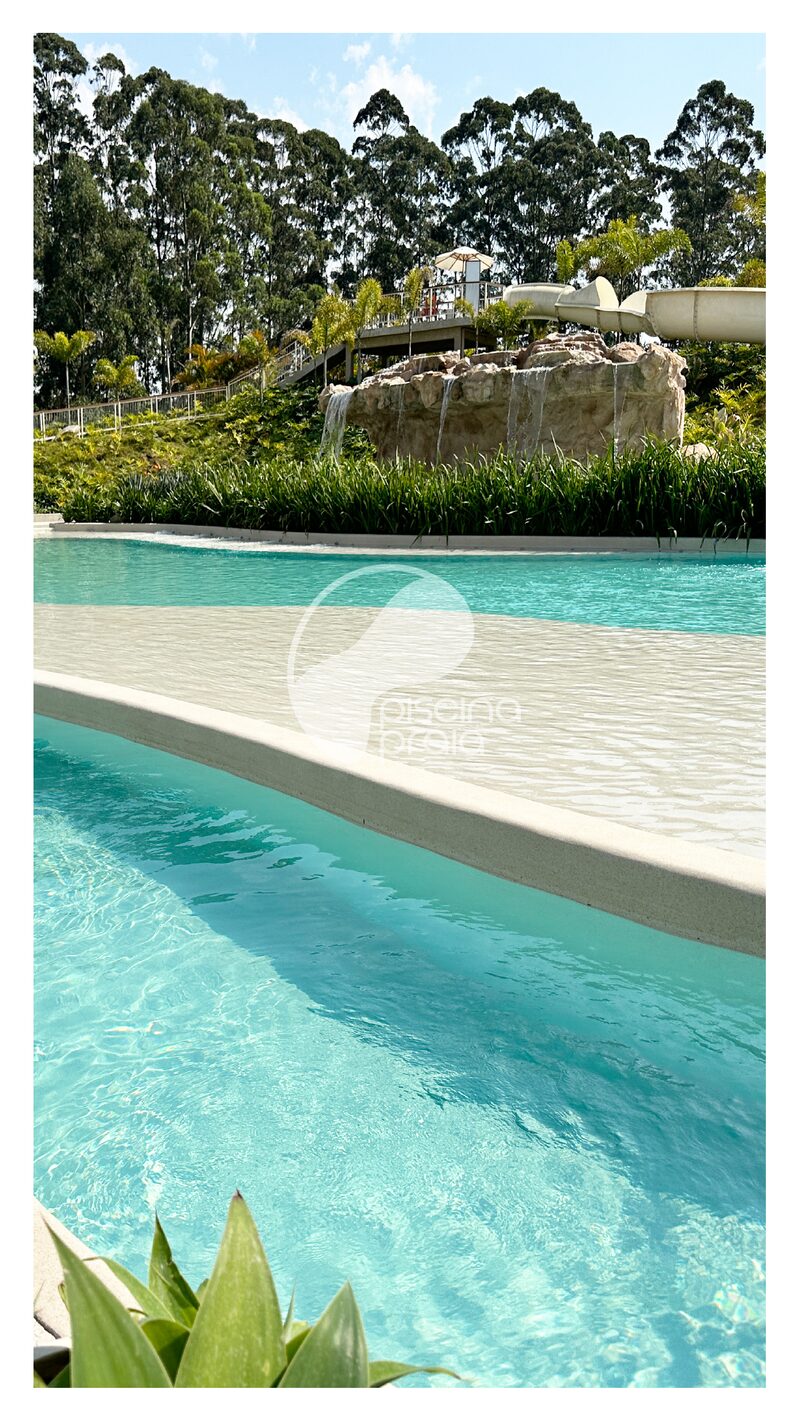 Piscina de água turquesa com prainha e jardim, vista da borda